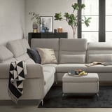 Modern living room with a gray FAMMARP sectional sofa, featuring cushions, a footstool, and decorative items.