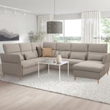 A modern gray FAMMARP sectional sofa with adjustable headrests and a white coffee table in a bright living room.