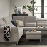 Modern living room with light gray FAMMARP sofa, black rug, and potted plant.