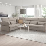 U-shaped gray sectional sofa with adjustable parts in bright living room, white coffee table, pendant lamp, large window.