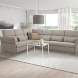 Modern grey l-shaped FAMMARP sofa with adjustable headrests and armrests, styled in a bright living room.