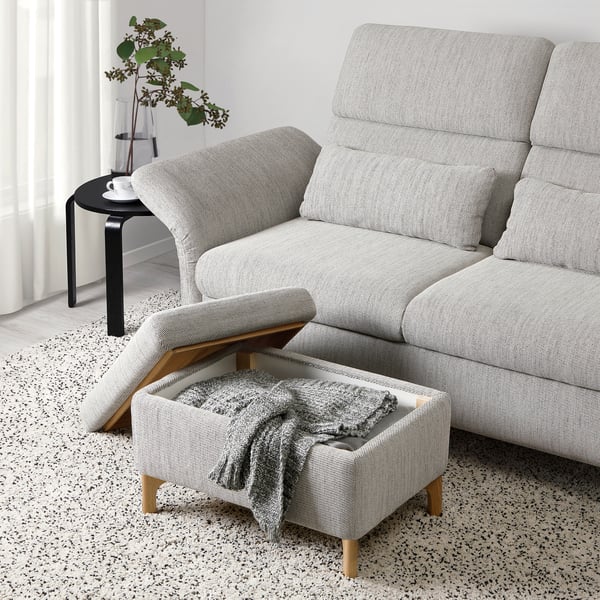 Modern grey sofa with adjustable headrests and a footstool with storage, perfect for relaxation and additional seating.