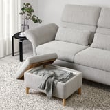 Modern grey sofa with adjustable headrests and a footstool with storage, perfect for relaxation and additional seating.