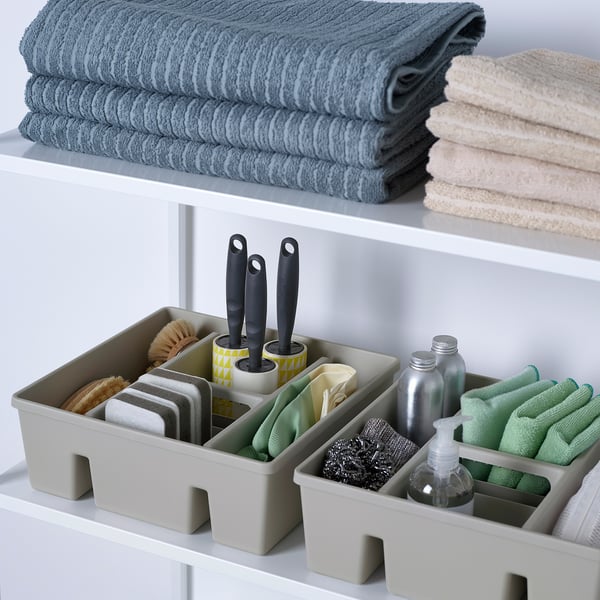 Organized cleaning supplies in compartments, including sponges, gloves, and brushes in a drawer insert.
