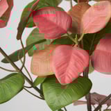 Vibrant artificial plant with deep green and bright pink leaves, arranged on a stem, showcasing lifelike quality and vivid color.