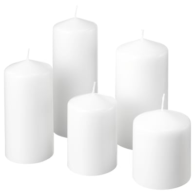 Six white pillar candles of varying heights, made from paraffin wax, arranged neatly together.