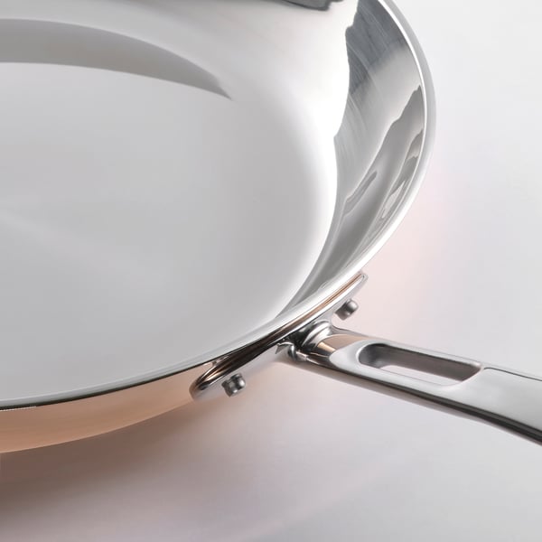 High-quality stainless steel frying pan with shiny, smooth surface and sturdy handle, reflecting light.
