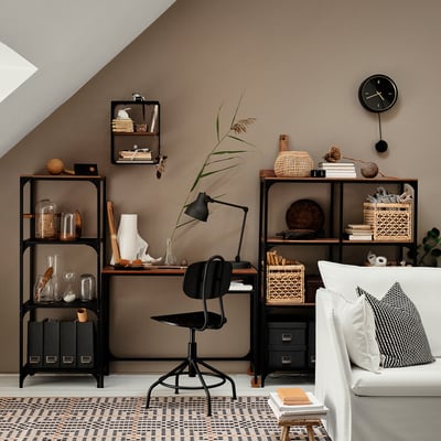 Modern home office with FJÄLLBO black metal and wood desk, chair, shelves, and decorations.