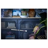 Black metal and wood storage unit with mesh doors, holding potted plants and photos.