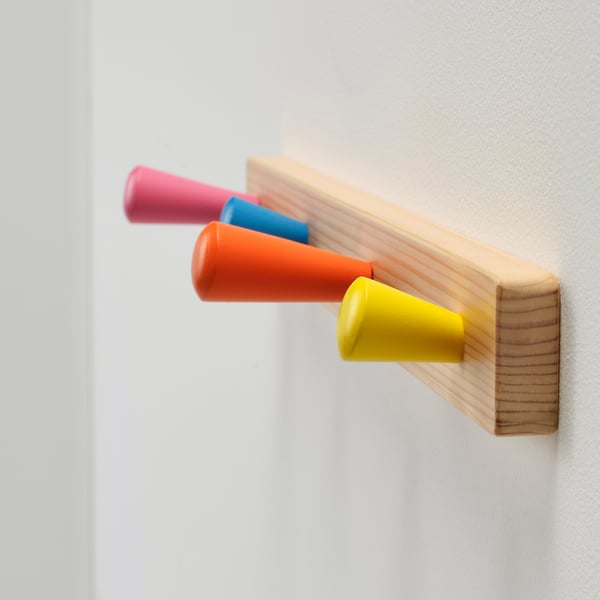 Four colorful hooks on wooden board.