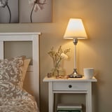 Citrus FLYGHÖJD lamp on bedside table, emits warm glow.