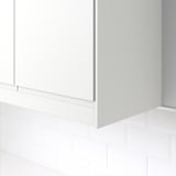White corner molding on tiled wall, hiding lighting units and cords under cabinets.