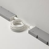 Two rectangular devices connected by a white cord for linking and controlling multiple lamps with a single power supply.