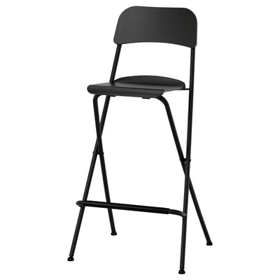 Black FRANKLIN bar stool with oak veneer seat and metal legs, designed for easy folding and storage.