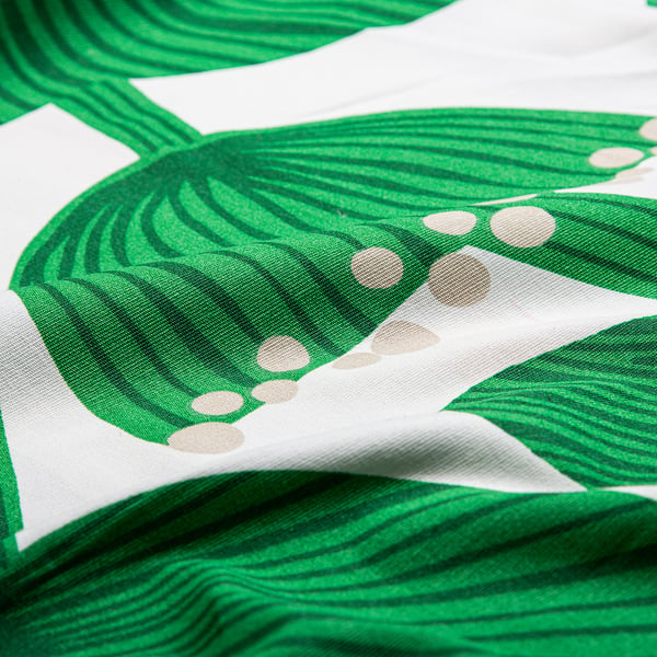 Close-up of high-quality, green leaf-patterned fabric on white background.