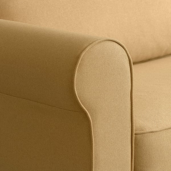 Tan upholstered sofa corner, showcasing soft fabric and clean stitching.