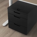 Black mobile filing cabinet with combination lock, three drawers, on wooden floor.