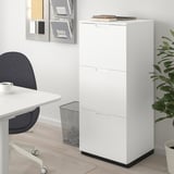 White GALANT storage cabinet with lock & adjustable feet, desk, blue chair, plant.