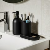 Modern bathroom set: soap dispenser, toothbrush holder, and tray on white sink. Soap dispenser and holder by GANSJÖN.