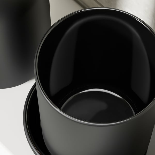 Black matte vase on reflective surface.