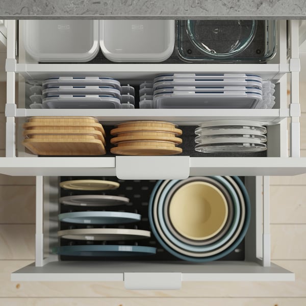 Ikea kitchen drawer with food containers, cutting boards, and bowls.