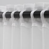 Sheer white curtains on black rod, allowing light with privacy.