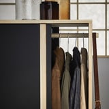 GLAMBERGET wooden coat rack with brown, green, black jackets; textured glass bottles on top.
