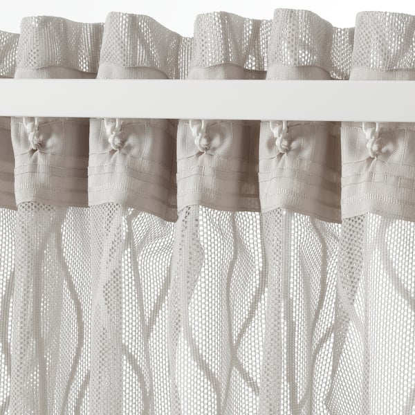 A pair of sheer wave-patterned grey curtains with hanging tabs, designed for privacy and light diffusion in home decor.
