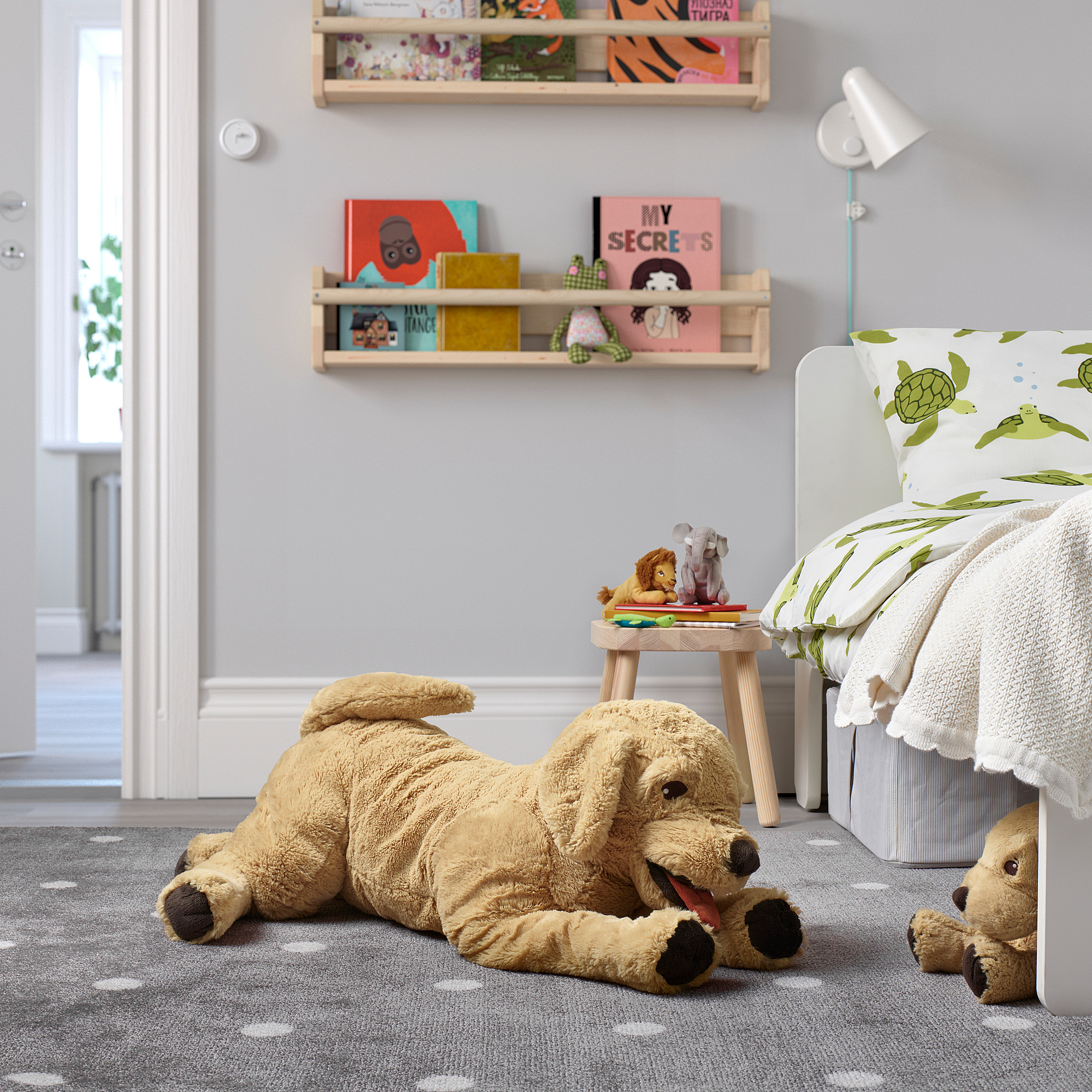 Large plush dog toy, GOSIG GOLDEN, in childs room amid toys & bed.