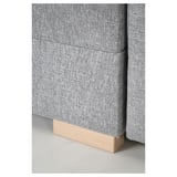 Close-up of modern sofa with light gray fabric and wooden legs, showcasing clean design and high-quality upholstery.