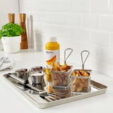 Stainless steel grill tray with baskets and bowls for serving grilled food. Includes condiment containers and tongs. Perfect for bbqs.