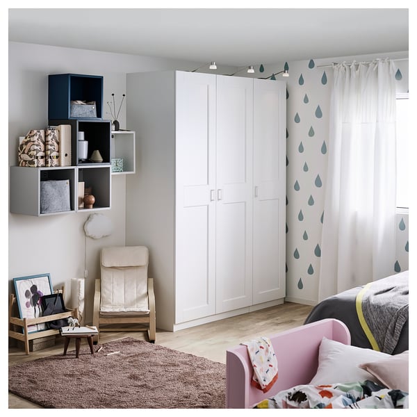 A modern bedroom with a white GRIMO wardrobe, featuring clean, bold frames and a beveled edge design.
