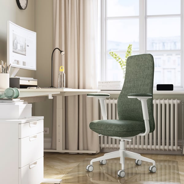 Modern home office with green GRÖNFJÄLL chair, large desk, computer, adjustable ergonomic support.