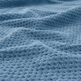 Close-up of soft, beige, textured cotton towel; feels thick, absorbent, and durable.