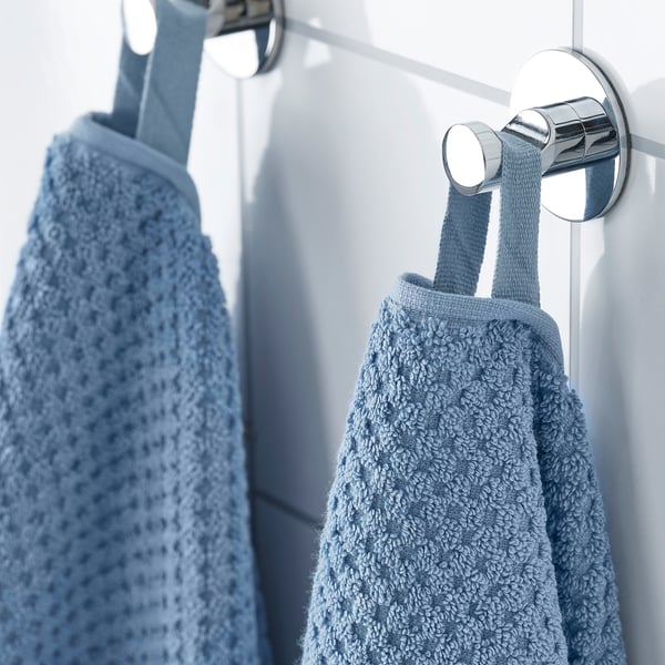 Two fluffy blue towels hang on chrome hooks. Soft, absorbent, and durable, perfect for daily use.
