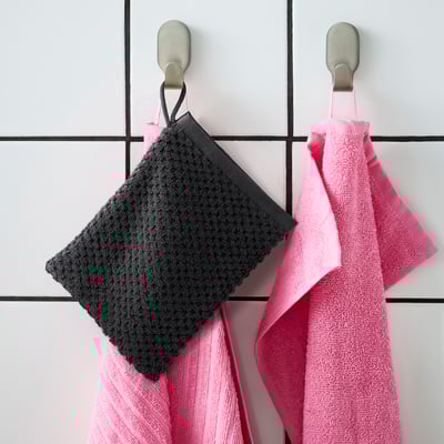 Hang two GULVIAL mitts: pink and grey, soft cotton, square, with loops, on grid wall hooks. Pink one larger.
