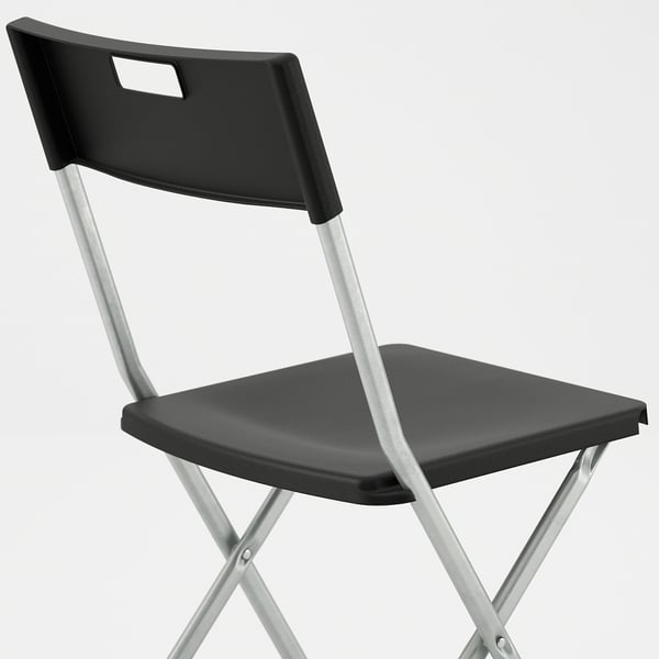 Black chair with metal legs, designed for stability and portability, a foldable design for easy storage.