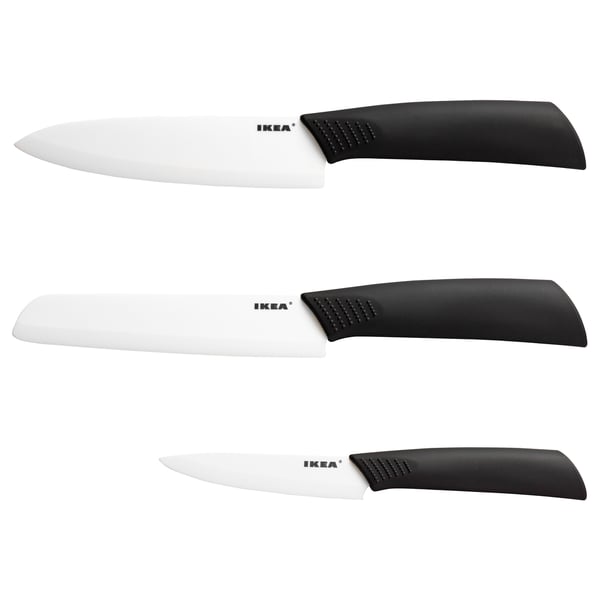 Three ceramic knives by ikea in black handles, sharp blades, arranged neatly.