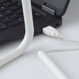 A sleek, adjustable desk lamp powered via usb, shown attached to a laptop, emitting warm white light.