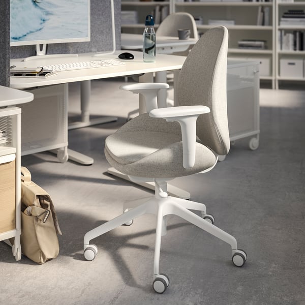 Érèse: modern office setup with light grey ergonomic chair, white desk, monitor, keyboard, mouse, and shelves.