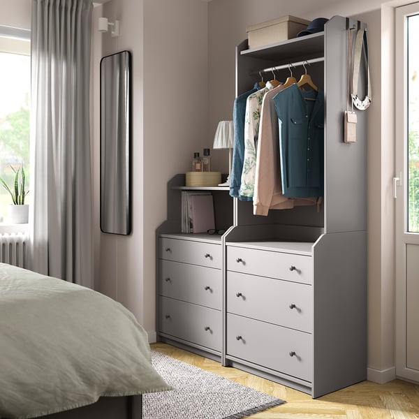 Modern bedroom with gray HAUGA wardrobe and storage. Gray curtains frame the window.