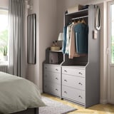 Modern bedroom with gray HAUGA wardrobe and storage. Gray curtains frame the window.