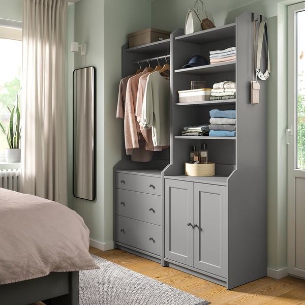Bedroom with grey HAUGA storage combo: shelves, drawers, & hanging space for clothes. Decorative items included.