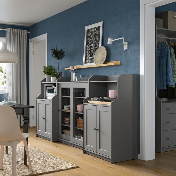 Modern kitchen with gray HAUGA cabinets, wooden floors, blue walls, and plants.