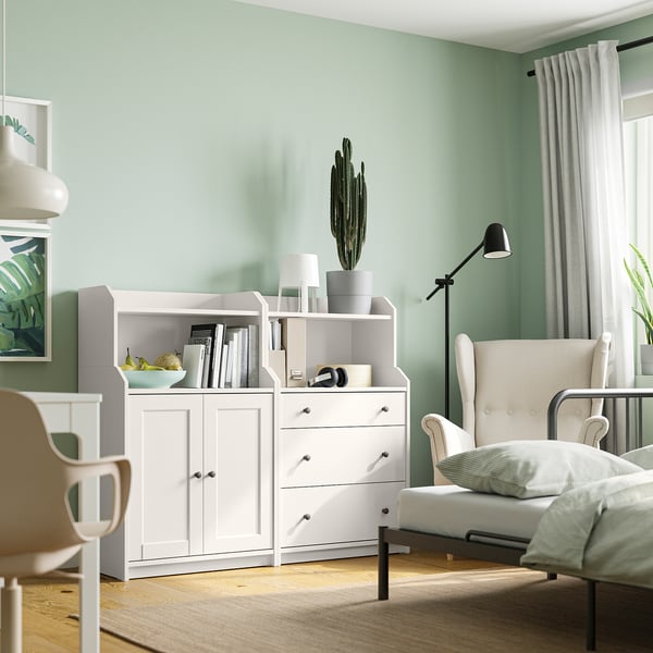 Light green living room with white furniture, wooden floor, natural light, HAUGA chest, cactus, & comfy chair.