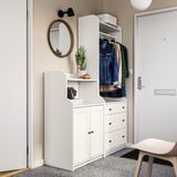 Modern entryway setup with white HAUGA storage, cactus, and hanging jackets.
