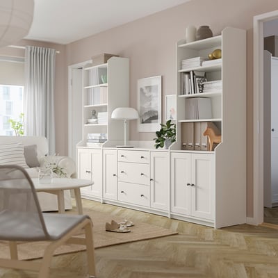 Modern living room with white HAUGA storage units, socks, lamp, and books.