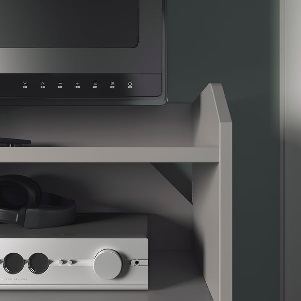HAUGA gray tv stand with shelf, headphones, and controls.