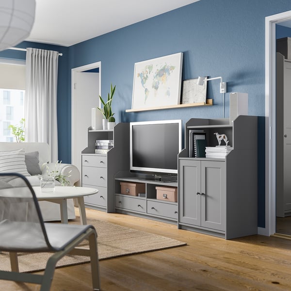 Modern living room with gray HAUGA furniture, including tv stand and shelves against blue wall.