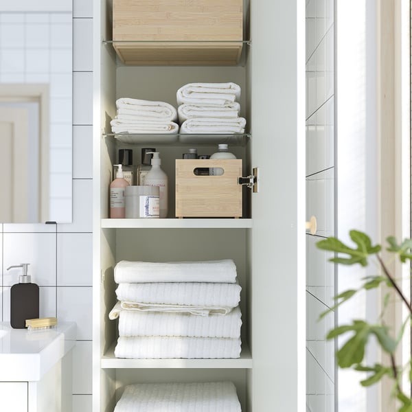 Bathroom cabinet maximizing wall space, storing towels and toiletries on shelves. The door mounts on either side, keeping items dust-free.